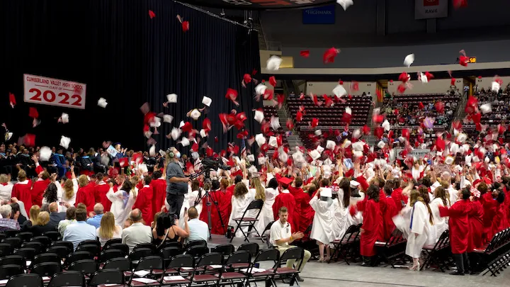 Graduation caps being thrown into the air at a graduation ceremony.